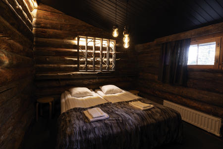 Schlafzimmer mit Doppelbett in den Kelo-Ferienhäusern vom Hotel Iso-Syöte