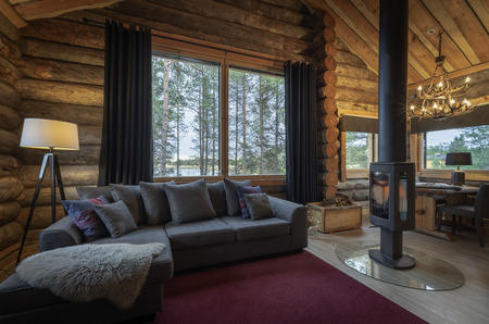 Offener Wohnbereich mit Kamin in den Log Cabins vom Wildnishotel Inari