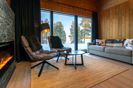 Wohnbereich mit elektrischem Kamin in den Panorama-Chalets vom Wildnis-Hotel Inari